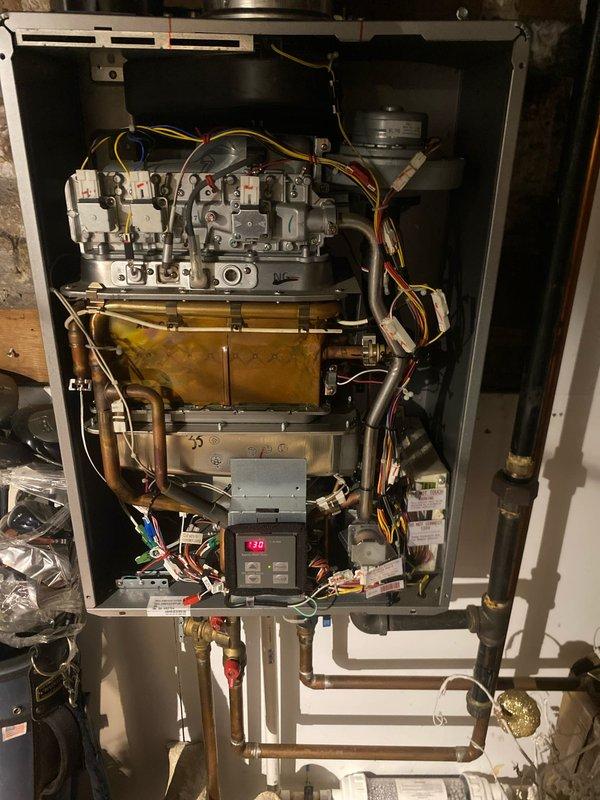 Responded to service call for tankless water heater displaying error code 12 and no hot water. Performed diagnostic inspection of unit, accessing internal components including control board which displayed "170" on digital readout. Identified and resolved issue with heat exchanger and control system, restoring proper functionality to the tankless water heater.