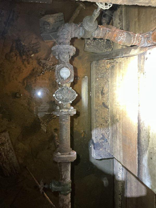 Conducted initial assessment of severely deteriorated commercial water main system showing extensive corrosion and mineral deposits. Documented aging pipes with multiple valves and joints in utility area requiring complete replacement. Will return to discuss replacement options and provide comprehensive estimate for the water main upgrade project.