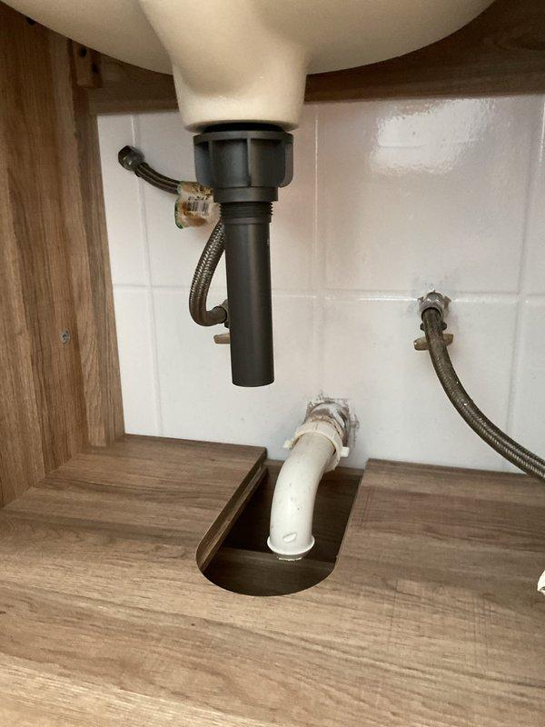 Completed installation of customer-supplied bathroom vanity including properly anchoring cabinet to wall and connecting sink drain assembly. Inspected existing drain line for blockages and ensured proper drainage. Sealed gap between vanity countertop and tile backsplash with appropriate waterproof caulking to prevent water intrusion.