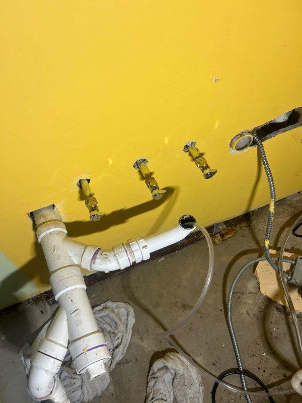 Responded to priority call regarding a leak behind kitchen sink wall. Upon inspection, identified damaged plumbing connections requiring immediate attention. Removed damaged section of piping, installed new PVC drain trap assembly with proper mounting brackets against wall, and verified system integrity. Leak successfully repaired with no further moisture issues detected.