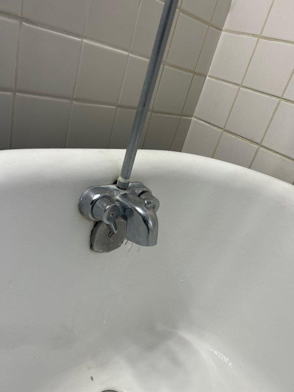 Responded to emergency service call for continuous hot water flow issue. Upon inspection, discovered faulty bathtub drain mechanism with visible wear and moisture accumulation. Replaced deteriorated chrome-plated faucet assembly with new dual-handle fixture, resolving the continuous flow problem and restoring proper water control functionality.