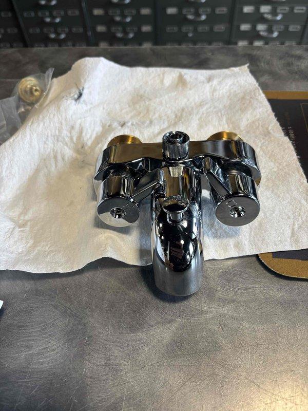 Responded to emergency service call for continuous hot water flow issue. Upon inspection, discovered faulty bathtub drain mechanism with visible wear and moisture accumulation. Replaced deteriorated chrome-plated faucet assembly with new dual-handle fixture, resolving the continuous flow problem and restoring proper water control functionality.