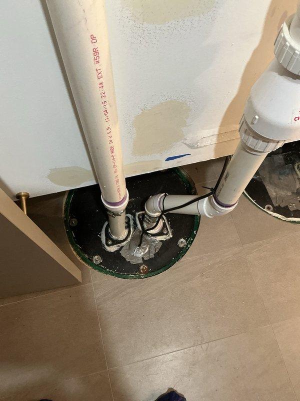 Completed callback service to assess sump pump installation in utility area. Inspected dual PVC discharge pipes with proper connections and verified integrity of basin with green ring. Noted and documented existing water staining on adjacent wall that may require future attention.