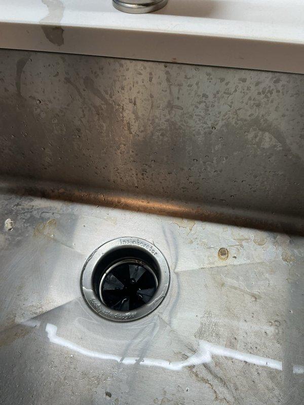 Responded to service call for clogged shower and kitchen sink. Inspected kitchen sink drain system, noting mineral buildup and water staining in basin. Examined garbage disposal unit and associated plumbing, ensuring proper connection and functionality. Cleared blockages from both drains, restoring normal water flow and proper drainage.
