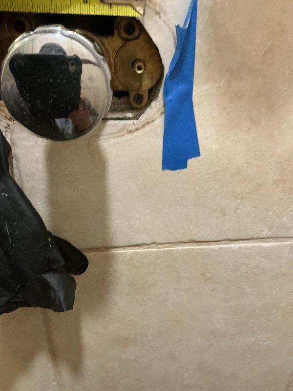 Responded to emergency call for a slow leak in shower isolation valve. Upon inspection, found brass valve assembly showing signs of corrosion with greenish patina developing around outer edges. Accessed valve through wall opening, documented condition with photos, and determined building water shutdown required for complete repair. Scheduled return visit for full valve replacement during planned building shutdown on 2/10/26.