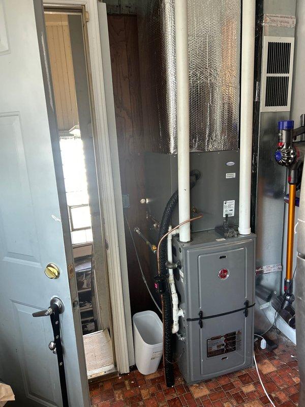 Inspected second-floor water heater with damaged drain line that froze and now discharges into a tenant-maintained bucket. Evaluated HVAC utility area and surrounding plumbing infrastructure to determine optimal repair solution for the compromised condensate drainage system.