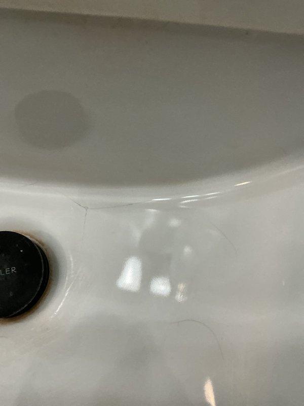 Inspected bathroom toilet for reported hairline fractures on porcelain surface. Documented existing stress cracks and minor discoloration on ceramic fixture. Customer requested specific technician exclusion for future service calls.