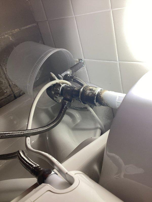 Responded to customer complaint of toilet leaking from wall for approximately 2 weeks. Inspection revealed aging water supply line with visible corrosion and mineral deposits at connection points. Replaced deteriorated metal braided supply line and tightened valve fitting to eliminate leak. Checked floor area for water damage and verified proper operation after repair.
