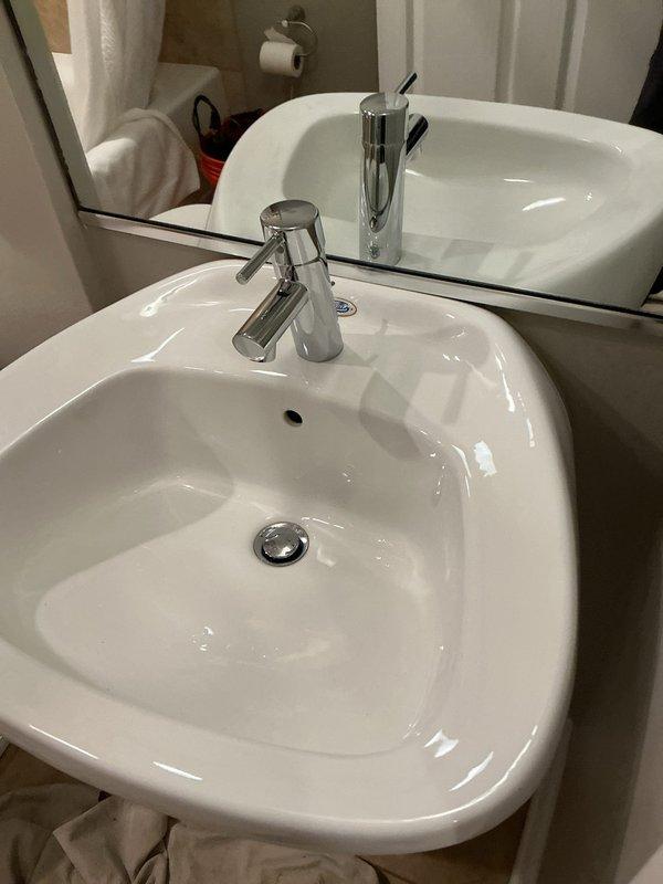 Successfully installed a new contemporary chrome faucet with cylindrical handle design on a white porcelain bathroom sink. Completed full installation with proper sealing and connection to existing plumbing. Final inspection confirmed proper water flow and no leaks.