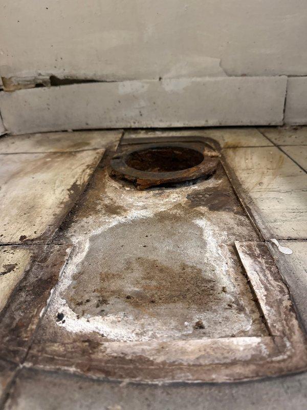 Completed replacement of severely corroded floor drain in commercial bathroom facility. Removed existing rusted fixture and installed new drain assembly with proper sealing to prevent water damage. Also inspected toilet with chrome flush valve and adjacent wall-mounted sink for potential related issues.