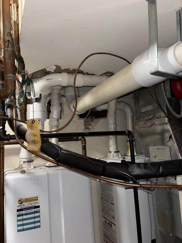 Completed warranty repair work on plumbing system, involving inspection and service of PVC drainage pipes, copper supply lines, and associated fittings in utility room. Addressed pipe penetration issues through ceiling and wall, ensuring proper installation and sealing around the water heater system as specified by service coordinator.