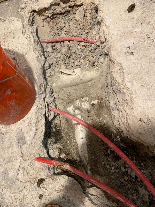 Excavated concrete floor to access and install PEX plumbing lines as part of basement renovation project. Installed multiple red PEX pipes through prepared trench, coordinating with ongoing construction. Project remains in progress pending final design approval and scheduling with general contractor.