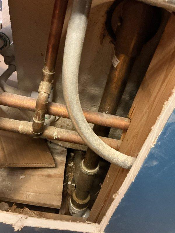 Investigated jacuzzi tub leak by accessing plumbing through wall cavity. Inspected copper supply lines and connections within wooden framed structure, noting oxidation on pipes. Located source of leak at connection point and repaired faulty fitting to restore proper function of tub.