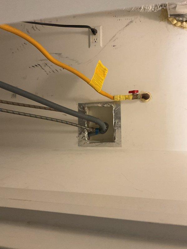 Responded to recurring backup issue in floor drain connected to washing machine. Observed significant mineral deposits and staining around floor drain with white PVC piping. Inspected plumbing configuration including copper pipes and drainage system in utility area. Noted potential water damage to surrounding tile flooring that may be contributing to drainage problems.