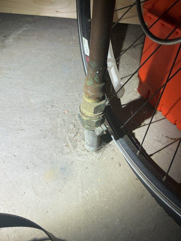 Located and identified source of high water consumption in 3-flat apartment building. Inspection revealed corroded copper pipe with significant oxidation and a compromised connection point. Found evidence of moisture intrusion and previous repair attempts using spray foam insulation around the plumbing components.