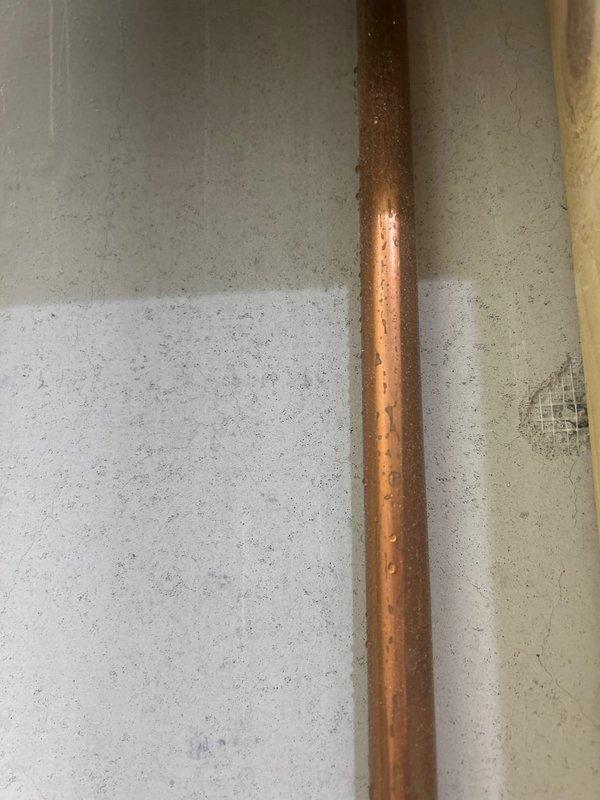 Inspected reported leak from second floor bathroom affecting kitchen below. Located copper supply line with visible water droplets/condensation. Examination of adjacent closet area revealed no signs of water damage to stored items. Diagnosed issue as minor condensation on supply pipe rather than active leak. No further repair action required at this time.