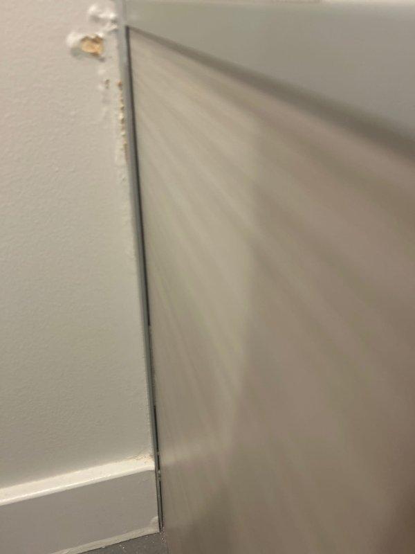 Responded to customer report of ceiling leak originating from bathroom/laundry room above. Conducted visual inspection of the area, identifying junction points between walls where moisture intrusion was occurring. Examined utility room plumbing configuration, focusing on L-shaped pipe arrangement and connections to mechanical systems. Located and documented the source of the water leak for future repair.