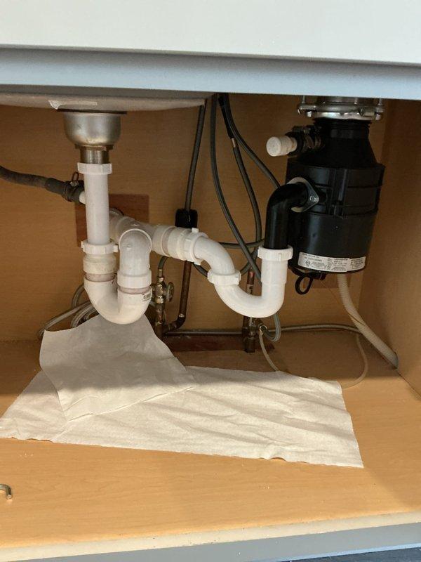 Installed new garbage disposal unit under kitchen sink, replacing existing system. Verified proper P-trap configuration and secured all PVC connections. Tested operation to confirm no leaks present at connection points.