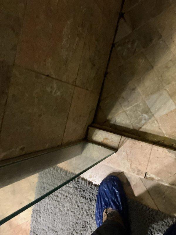 Responded to a water leak affecting a downstairs unit. Upon inspection, identified water seepage from the bathtub surround area where deteriorated grout and caulking had failed at the tub-to-wall junction. Removed compromised sealing materials, thoroughly dried affected areas, and applied new silicone caulking to create proper waterproof barrier around tub perimeter and along floor junction to prevent further water intrusion.