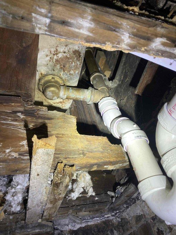 Returned to address bathtub leak affecting basement unit. Inspection revealed corroded brass/copper pipes with significant oxidation at transition points to PVC drainage components. Replaced deteriorated plumbing connections and sealed junction points to prevent further water damage to surrounding wooden joists and structural elements that showed signs of previous moisture exposure.