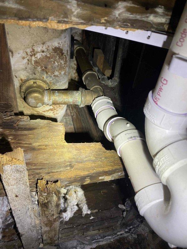Returned to address bathtub leak affecting basement unit. Inspection revealed corroded brass/copper pipes with significant oxidation at transition points to PVC drainage components. Replaced deteriorated plumbing connections and sealed junction points to prevent further water damage to surrounding wooden joists and structural elements that showed signs of previous moisture exposure.