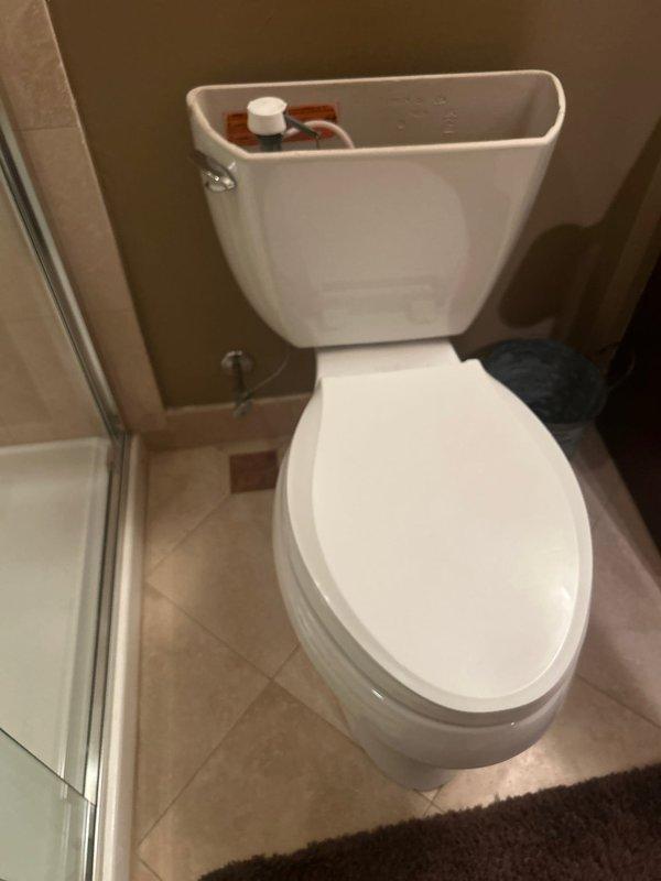 Completed toilet service involving removal of tank lid to access and repair the internal flush mechanism. Inspected water supply line, shutoff valve, and connection hose - all components in good working condition with no visible leaks or corrosion. Reinstalled tank lid and verified proper operation before completing service.