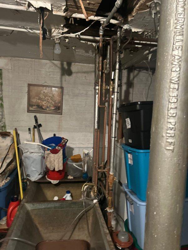 Conducted inspection of leak issue in two-flat building where kitchen water was penetrating into basement area. Investigation revealed deteriorated copper supply lines with significant corrosion at multiple connection points. Documented existing plumbing configuration including exposed piping, valves, and utility area to prepare comprehensive repair plan for replacement of damaged sections.