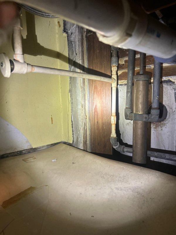 Conducted inspection of leak issue in two-flat building where kitchen water was penetrating into basement area. Investigation revealed deteriorated copper supply lines with significant corrosion at multiple connection points. Documented existing plumbing configuration including exposed piping, valves, and utility area to prepare comprehensive repair plan for replacement of damaged sections.