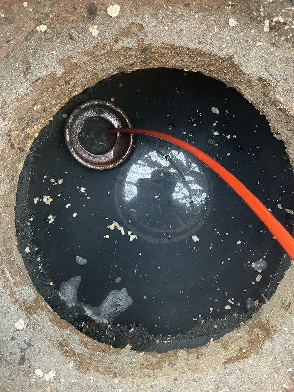 Performed camera inspection of catch basin outlet as requested. Observed significant mineral deposits, debris accumulation, and standing water within the drain pipe. Identified potential blockage requiring rodding service. Documentation photos taken showing pipe interior condition and access point with visible sediment buildup.