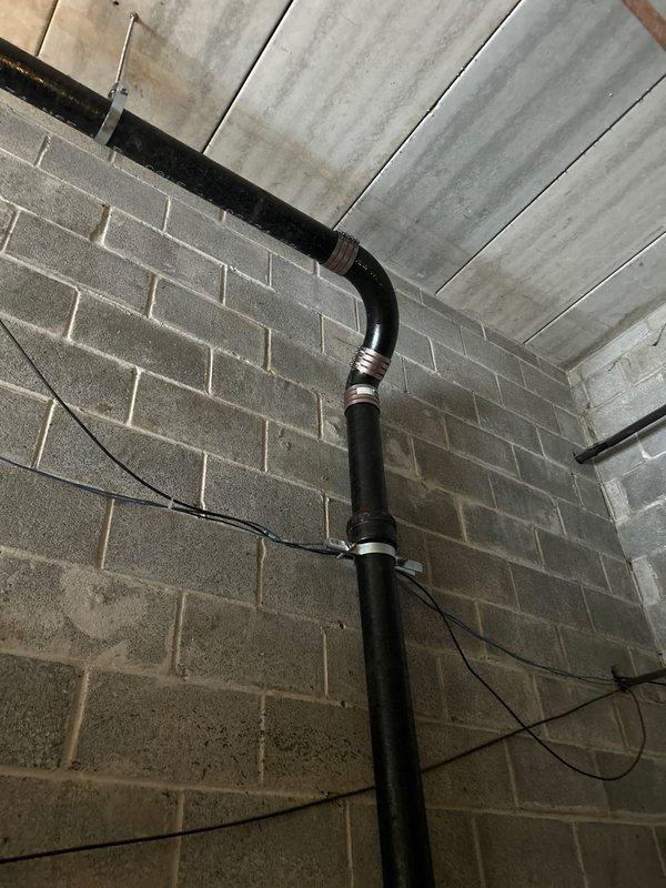 Conducted initial assessment of commercial plumbing system, documenting copper pipe network and control junction box installation in utility area. Identified and photographed vertical black pipe with 90-degree bend near ceiling in concrete block wall section. Second service call scheduled for 2/10/26 to complete necessary repairs.