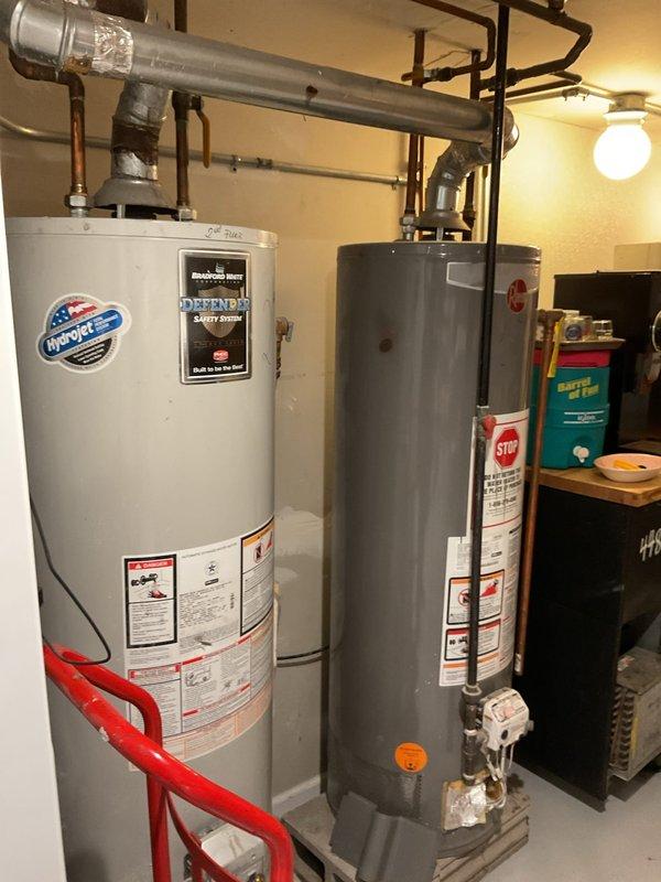 Conducted a site assessment for potential tankless water heater installation at customer's tavern. Current setup includes two conventional tank water heaters (one Rheem Performance model) with standard copper piping and metal exhaust venting. Evaluated existing utility room configuration and plumbing connections to determine feasibility of conversion to tankless system.