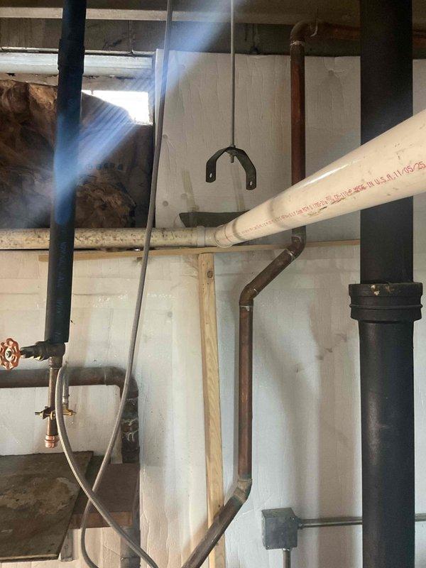 Conducted comprehensive assessment of existing plumbing infrastructure, focusing on drain line system with black ABS pipe connected to PVC components. Evaluated copper supply lines and valve assemblies in utility area. Documented current installation configuration with particular attention to drainage pathways and connection points for proposed fixture installation. Photos taken to support estimate preparation.