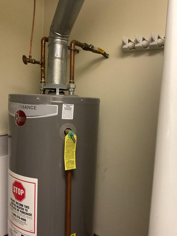 Responded to service call regarding shower temperature adjustment issues. Diagnosed and repaired thermostatic mixing valve in dual-head shower system with chrome fixtures. Verified proper water heater operation (Rheem Performance model) with all connections secure and functioning correctly.