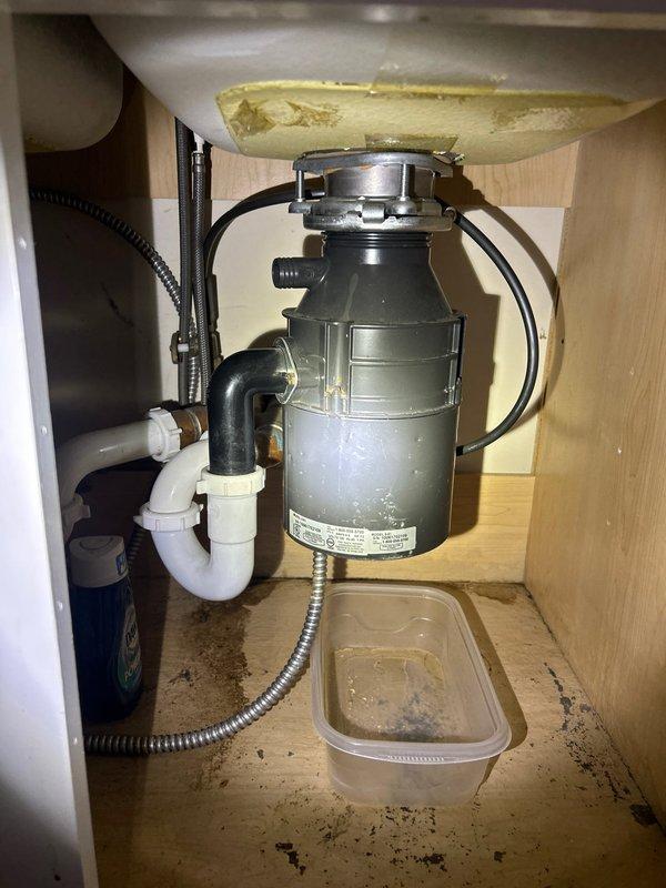 Responded to service call for garbage disposal inspection after 2pm as requested. Identified water damage and moisture stains in cabinet beneath kitchen sink, likely from leaking disposal unit connections. Examined plumbing configuration including drain pipe connections and water supply lines, documented condition with photos, and performed necessary adjustments to resolve the leakage issue.