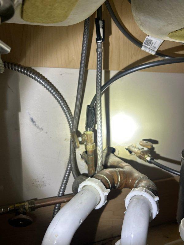 Responded to service call for garbage disposal inspection after 2pm as requested. Identified water damage and moisture stains in cabinet beneath kitchen sink, likely from leaking disposal unit connections. Examined plumbing configuration including drain pipe connections and water supply lines, documented condition with photos, and performed necessary adjustments to resolve the leakage issue.