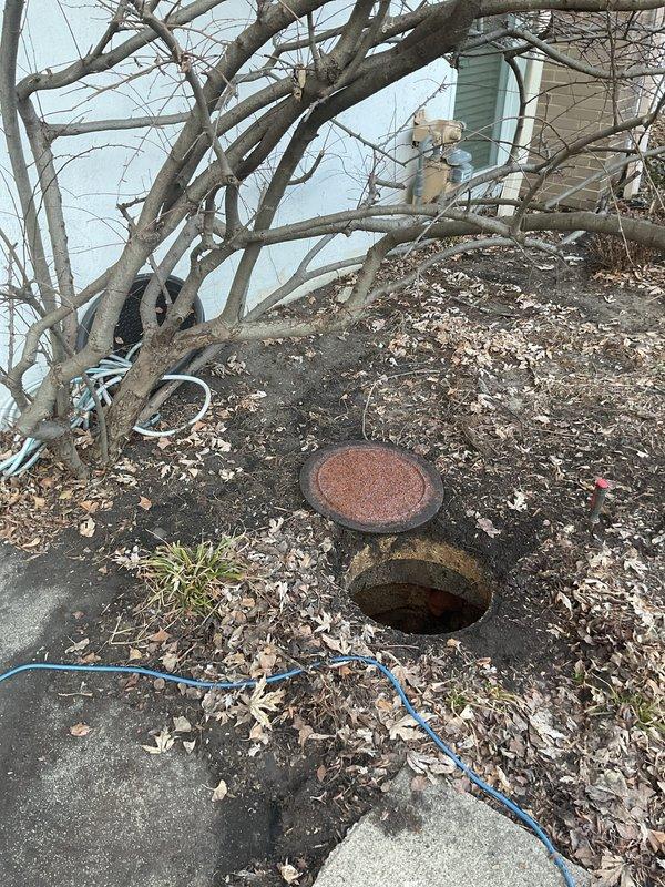 Performed downspout rodding service to clear blockage in exterior drainage system. Accessed underground drain cleanout point and successfully removed accumulated debris, including leaf matter that was causing obstruction. System is now functioning properly with proper water flow restored.