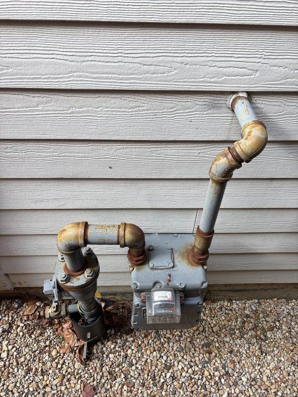 Diagnosed boiler error code issue in basement installation. Inspection revealed significant corrosion on exterior gas meter connections and piping. Serviced red circulator pump and expansion tank system to resolve error codes, ensuring proper functionality of the heating system.