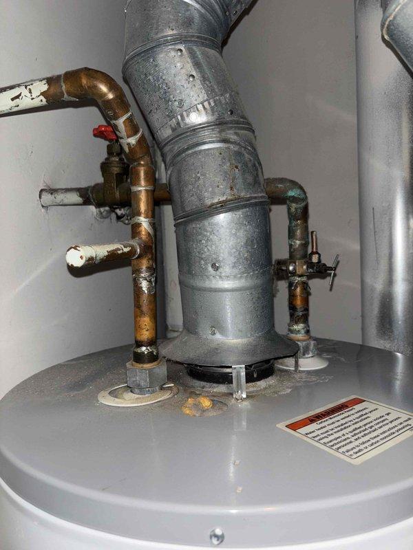Responded to a water leak service call involving a residential water heater system. Upon inspection, identified mineral buildup and oxidation around copper pipe connections at the top of the water heater tank, which was causing seepage. Cleaned affected connections, tightened fittings, and verified proper operation of the pressure relief valve and associated plumbing components to resolve the leak issue.