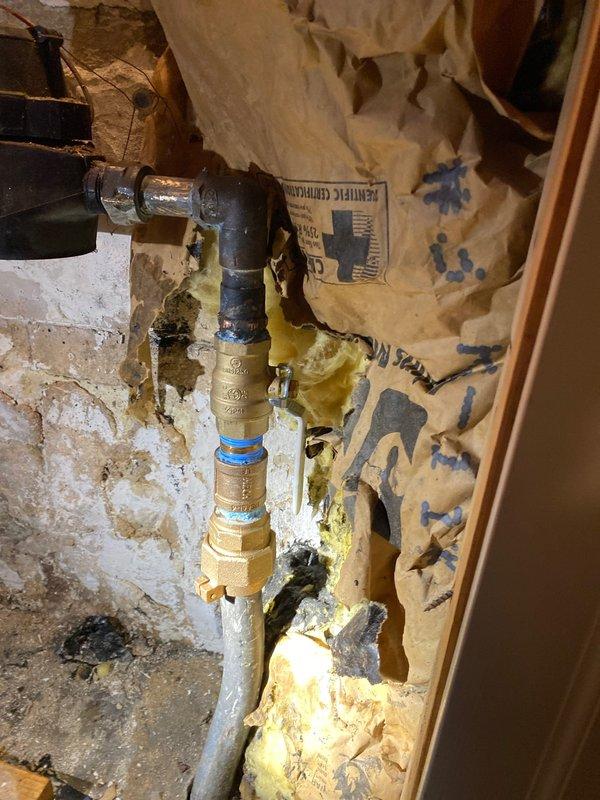 Completed replacement of severely corroded copper supply pipe and failed brass shut-off valve that showed significant oxidation and mineral buildup. Installed new 90-degree elbow fitting with brass valve components and connected to existing plumbing, ensuring proper sealing and function at connection points within the wall cavity.
