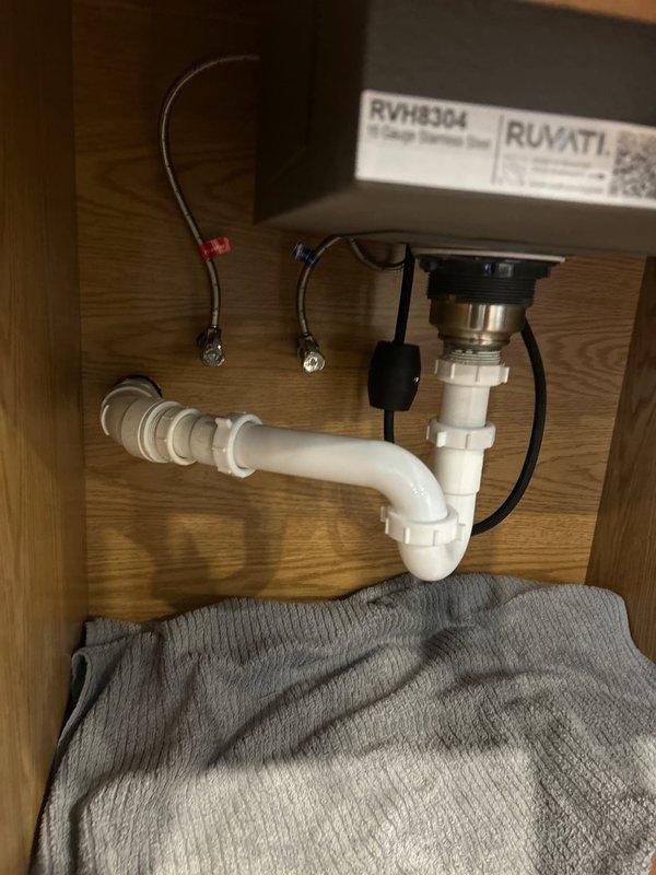 Successfully installed a 15" Ruvati undermount sink and gooseneck faucet for wet bar, connecting all necessary plumbing components including P-trap assembly and supply lines. Completed final testing with water flow to verify proper drainage and absence of leaks in the new installation.