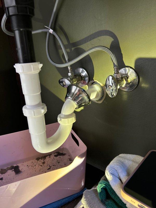 Replaced cracked J-bend (P-trap) on bathroom sink after customer's unsuccessful DIY attempt. Installed customer-provided replacement part and verified proper drainage with no leaks at all connection points.