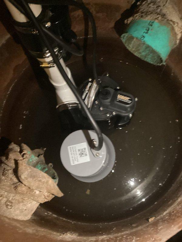 Diagnosed and serviced Ion Storm Pro 35ACi+ Battery Backup System that was beeping intermittently. Inspected sump pit containing the primary pump with float switch and battery backup system, noting sediment accumulation and mineral deposits on concrete walls. Verified system functionality with control panel showing 83% battery capacity and all indicator lights functioning properly.