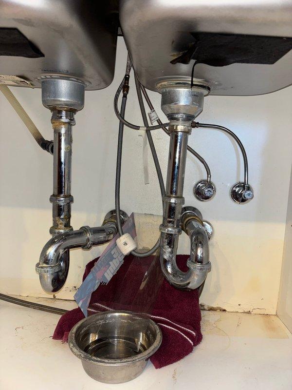 Replaced kitchen faucet and repaired leak under double-basin sink by installing new P-trap assemblies and sealing connections. Restored hot water service to bathroom shower by repairing valve components and ensuring proper water flow.