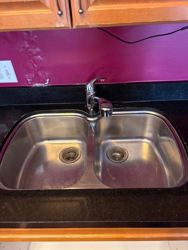 Replaced kitchen faucet and repaired leak under double-basin sink by installing new P-trap assemblies and sealing connections. Restored hot water service to bathroom shower by repairing valve components and ensuring proper water flow.