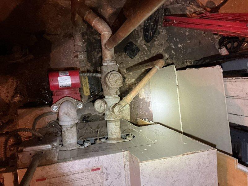 Responded to service call regarding no hot water in commercial building. Upon inspection of the HVAC/boiler system, observed aging copper piping with surface corrosion, a circulation pump with red motor component, and examined the internal wiring and components of the heating unit. Diagnostic assessment performed on the 50-gallon water heater which had failed the previous day.