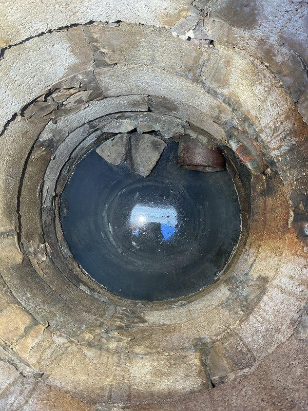 Responded to service call regarding deteriorated drainage structure. Inspected circular drainage pipe showing significant concrete deterioration with extensive cracking, flaking, and water pooling at bottom. Also examined utility access area with PVC piping and documented current condition with photographs for further assessment.