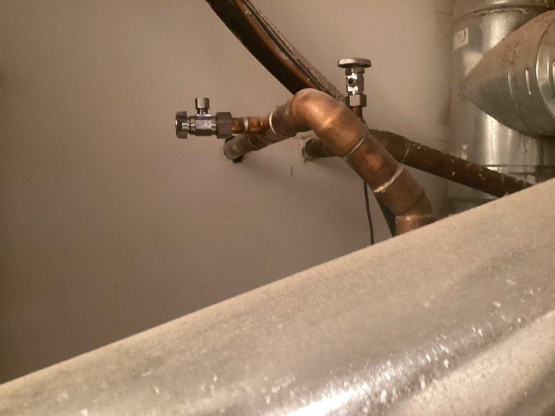 Completed copper pipe repair in utility area, replacing damaged sections and installing new shut-off valve. System now functions properly with no leaks at connection points and proper flow through the newly installed components.