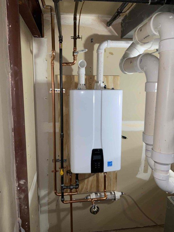 Installed new tankless water heater with complete copper pipe network and proper shut-off valves. Mounted unit securely on plywood backing board with appropriate venting system using PVC pipes and elbow joints. Installed condensation catch tray and tested all connections to ensure proper operation and energy efficiency.