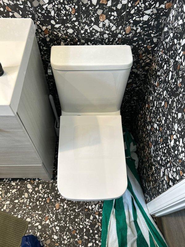 Responded to service call regarding toilet leaking onto floor in 70-year-old residence. Upon inspection, identified a corroded drain fixture in the terrazzo flooring as the source of the leak. Replaced broken steel component and verified proper operation of the toilet with no further leakage.