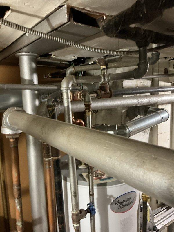 Responded to service call for reported gas leak. Upon inspection, identified leaking connection points in the basement gas line system that included galvanized and copper piping with multiple valves and joints. Observed water damage on ceiling/subflooring near plumbing fixtures, suggesting possible correlation with the gas line issue. Performed pressure test to confirm leak location, repaired compromised connections, and restored gas service after verifying system integrity.